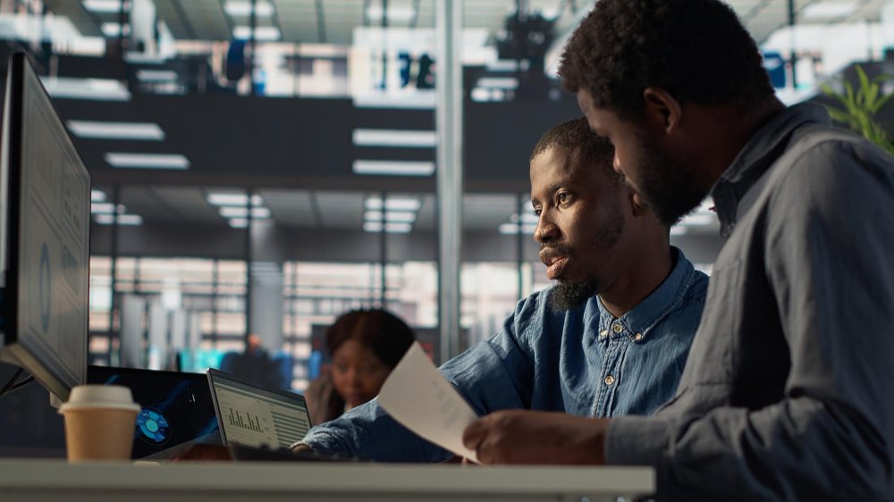 Two African web developers collaborating on a project in a modern digital office — representing Santangfara’s commitment to innovative web design and tech solutions in The Gambia.